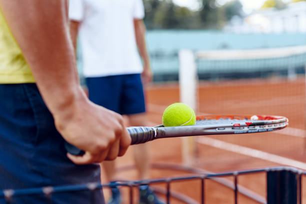 Tennis player's hand preparing to take a serve on court
